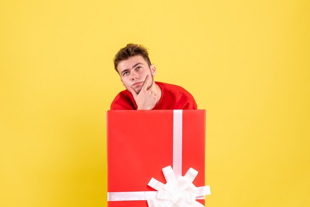 Front view young male standing inside present box thinking