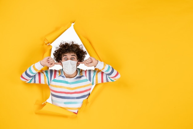 Free photo front view young male in sterile mask on yellow health color covid human photo pandemic