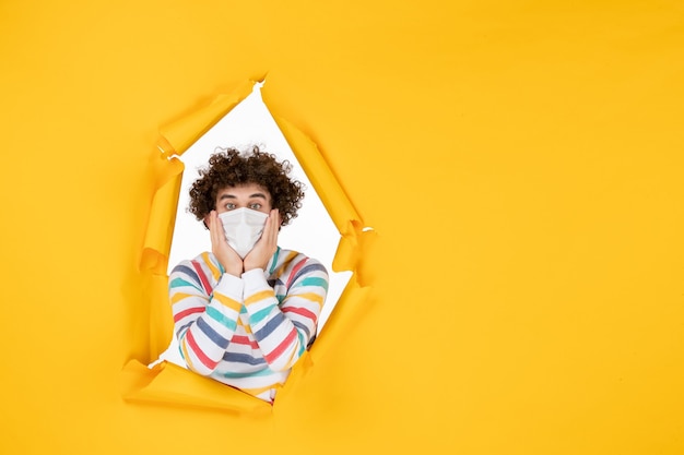 Front view young male in sterile mask on yellow health color photo covid- pandemic human