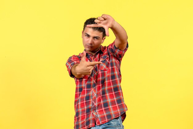 Front view young male taking picture on yellow background