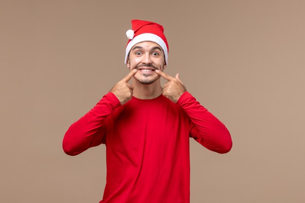 Front view young male trying to smile on brown background emotion holiday male