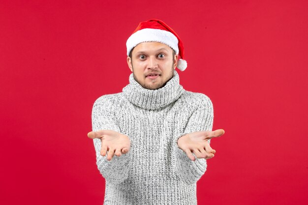 Front view young male in warm jersey on red wall