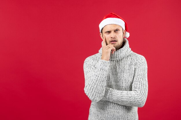 Front view young male in warm jersey on red wall