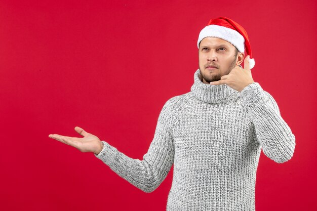 Front view young male in warm jersey on red wall