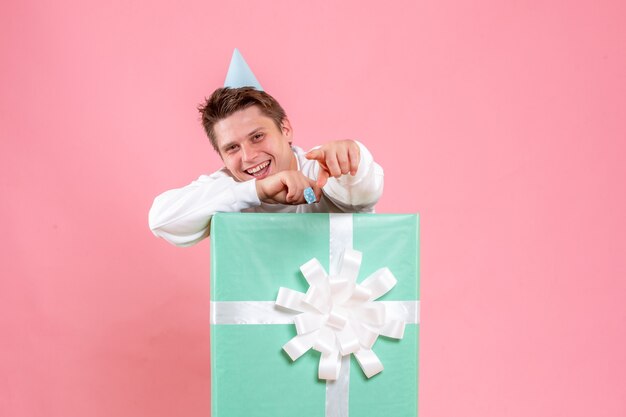 Front view young male in white shirt with cap and present laughing on a pink background