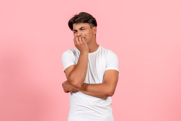 Front view young male in white t-shirt feeling nervous on pink background