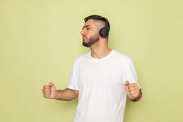 A front view young male in white t-shirt listening to music