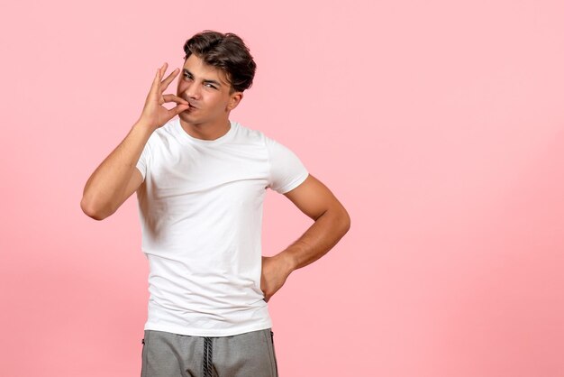 Front view young male in white t-shirt on a pink desk