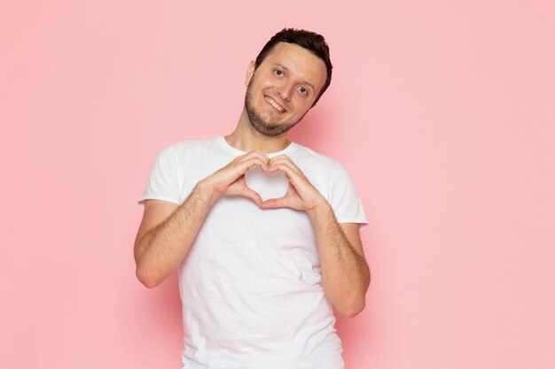 A front view young male in white t-shirt posing with delighted love expression