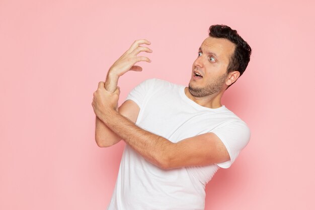 A front view young male in white t-shirt posing with funniest manner