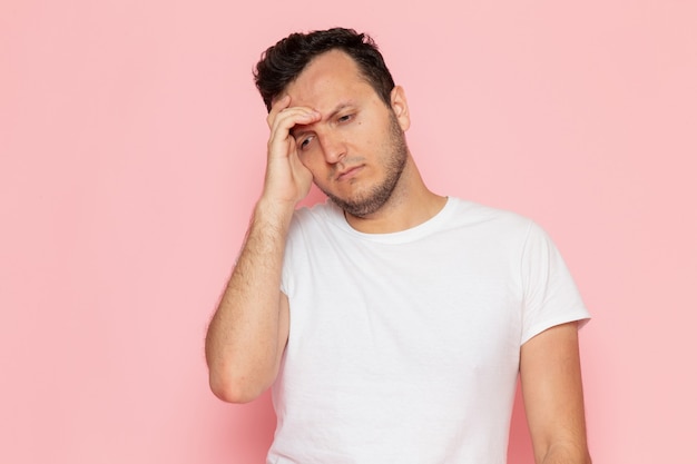 A front view young male in white t-shirt posing with stressed out expression