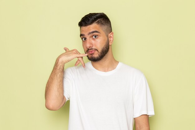 A front view young male in white t-shirt showing phone call sign