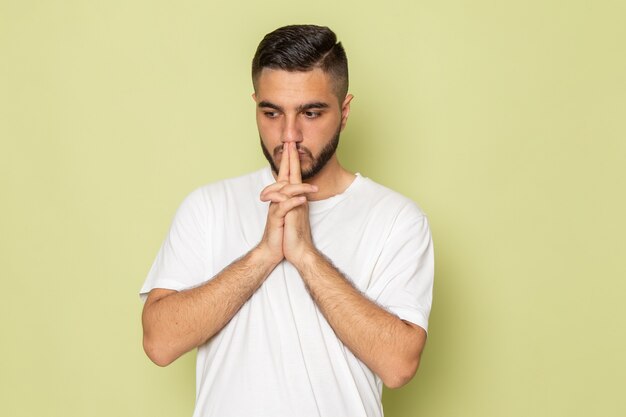 A front view young male in white t-shirt thinking