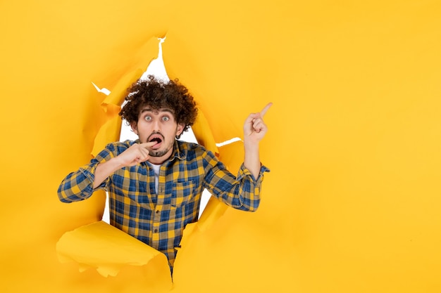 Free photo front view young male with curly hair on yellow ripped background