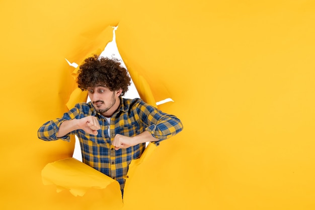 Free Photo front view young male with curly hair on yellow ripped background