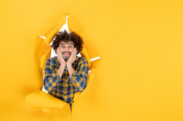 Front view young male with curly hair on yellow ripped background