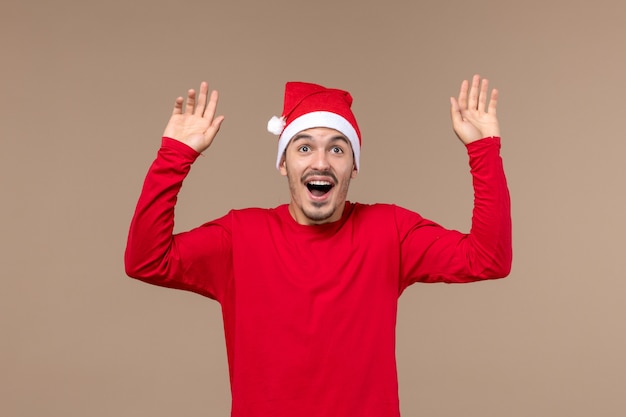 Front view young male with excited expression on brown background christmas emotion holiday