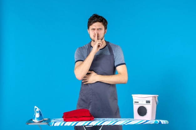 Free photo front view young male with ironing board on blue background housework colors iron laundry washing machine man cleaning