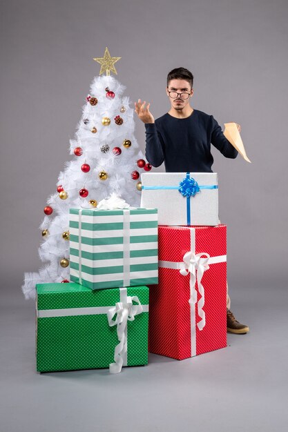 Front view young male with presents and envelop on grey