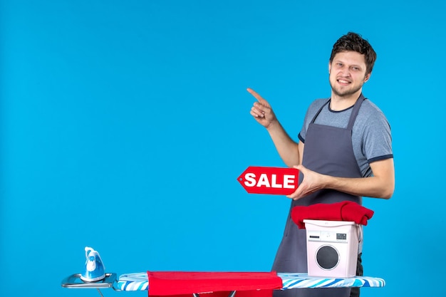 Front view young male with red sale writing in his hands on the blue surface