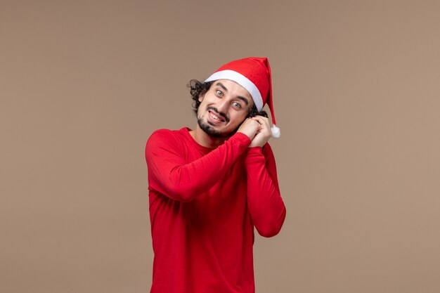 Front view young male with smiling expression on the brown background holiday christmas emotion