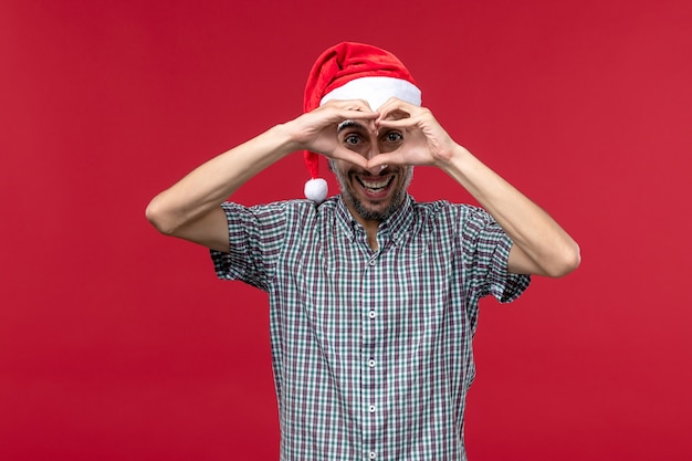 Free photo front view young male with smiling expression on red background