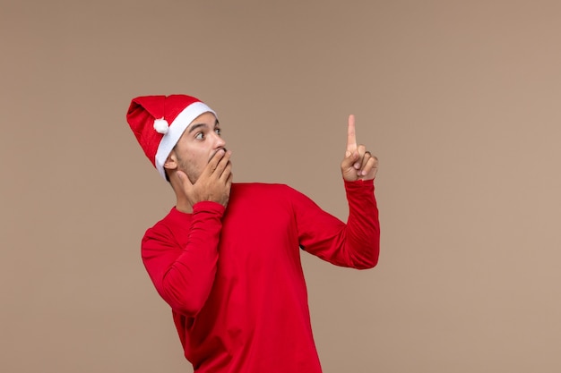 Free photo front view young male with surprised expression on brown background christmas emotion holiday male