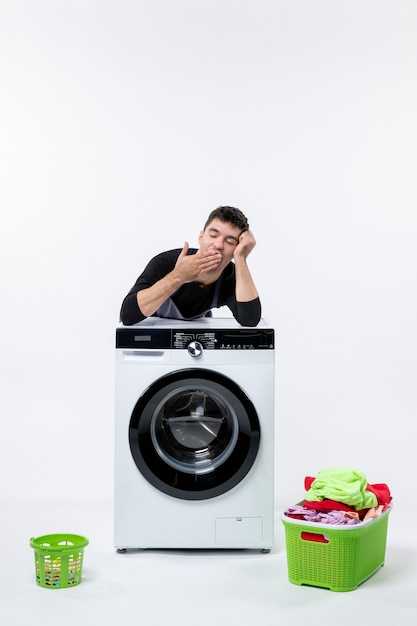 Free photo front view of young male with washer and dirty clothes on white wall