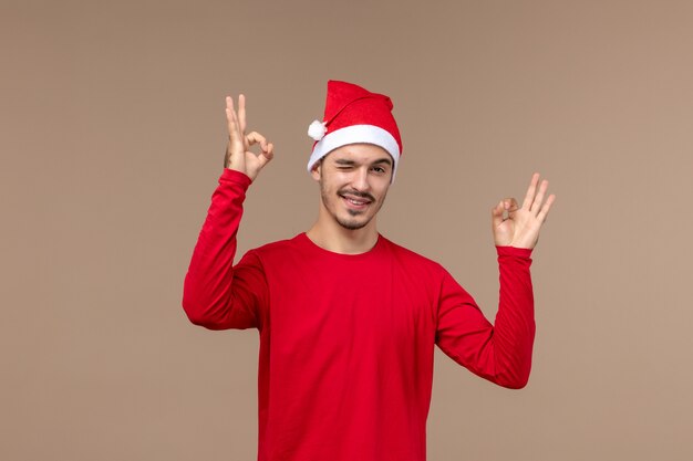 Front view young male with winking expression on brown background emotions holiday male