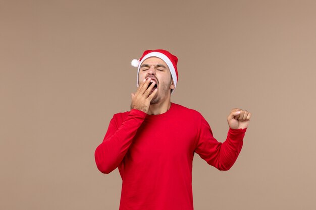 Front view young male yawning on brown background christmas emotion holiday male