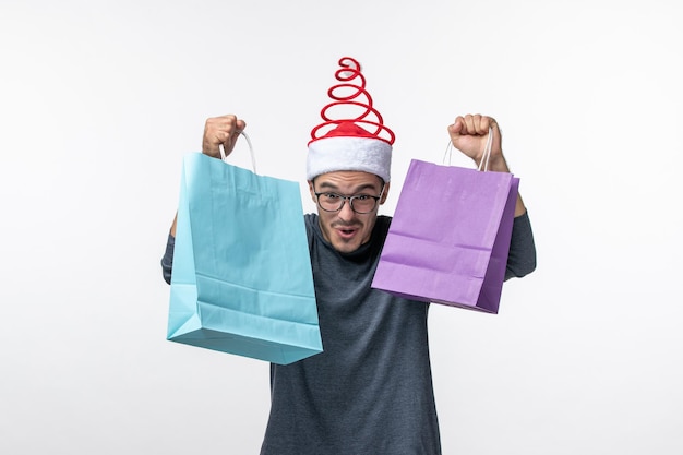 Free Photo front view of young man after holiday shopping on white wall