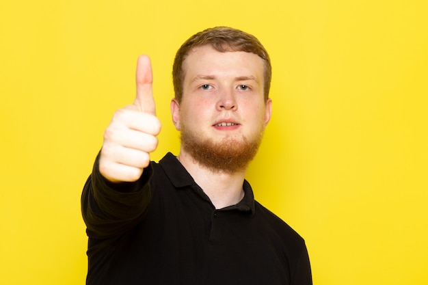 Front view of young man in black shirt posing showing like sign