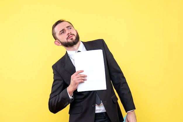 Free Photo front view of young man businessman bewildered looks aside and holdis document on yellow