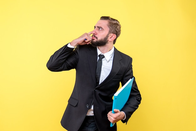 Front view of young man businessman pressing his pointing finger over head dealing with tasks on yellow