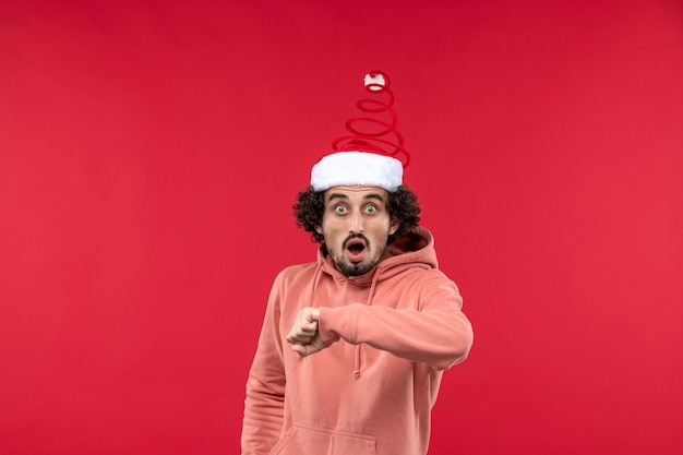 Free Photo front view of young man checking time on a red wall