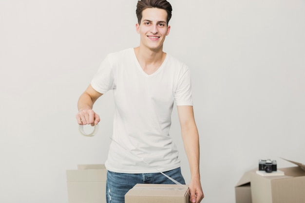 Free Photo front view young man holding cello tape