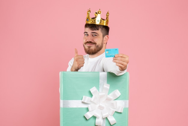 Free photo front view of young man inside present box with crown on pink wall