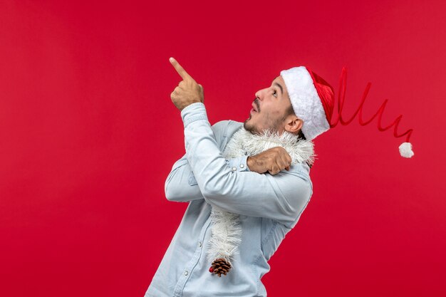 Free photo front view of young man looking at ceiling on red wall