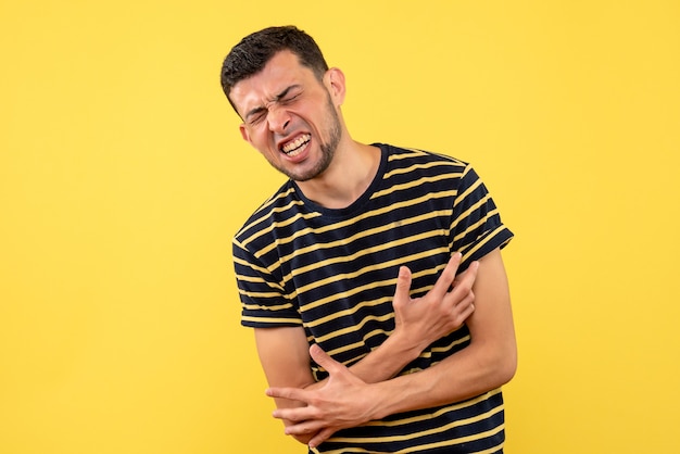 Free photo front view young man in pain standing on yellow isolated background