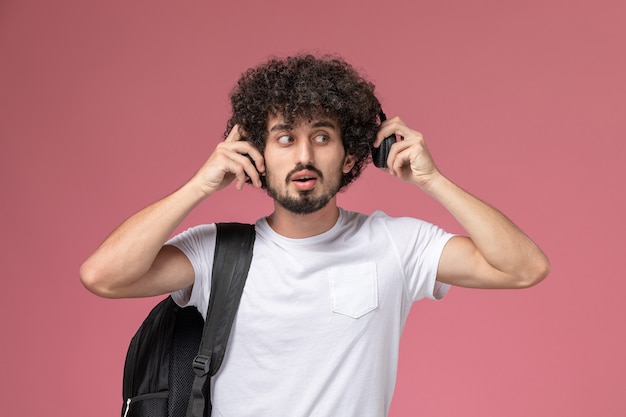 Front view young man using one side of headphone to listen song