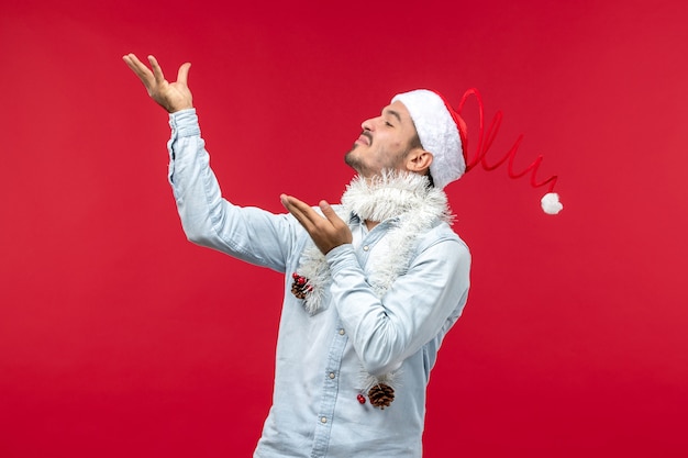 Front view of young man with delighted expression on red wall