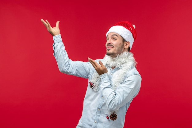 Front view of young man with delighted expression on red wall