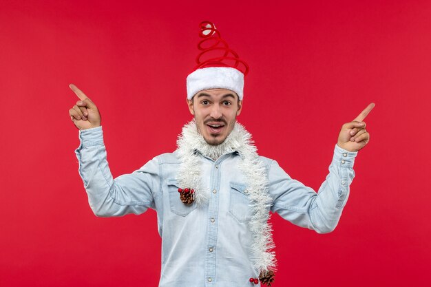 Front view of young man with excited expression on a red wall