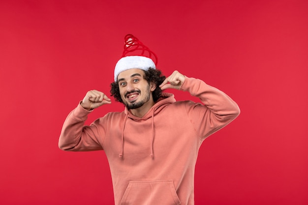 Front view of young man with excited expression on a red wall