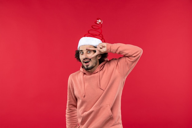 Front view of young man with excited expression on the red wall