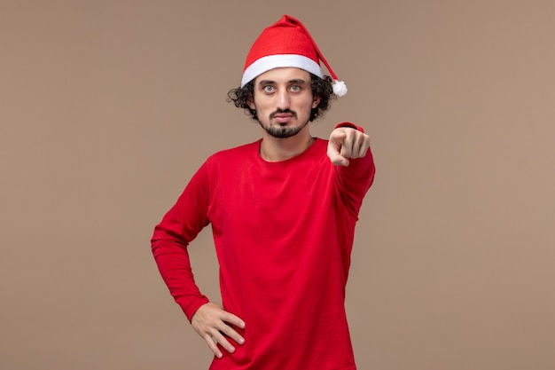 Free Photo front view young man with red christmas cape on a brown background holiday emotions christmas