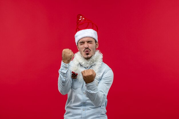 Front view of young man with rejoicing expression on red wall