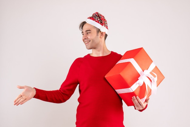 Front view young man with santa hat giving hand on white background