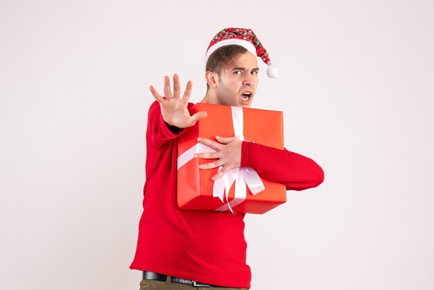 Front view young man with santa hat holding gift on white background