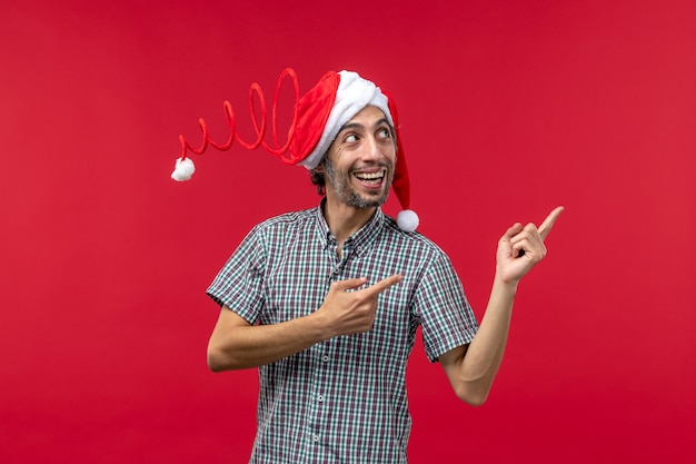 Free photo front view of young man with smiling expression on a red wall